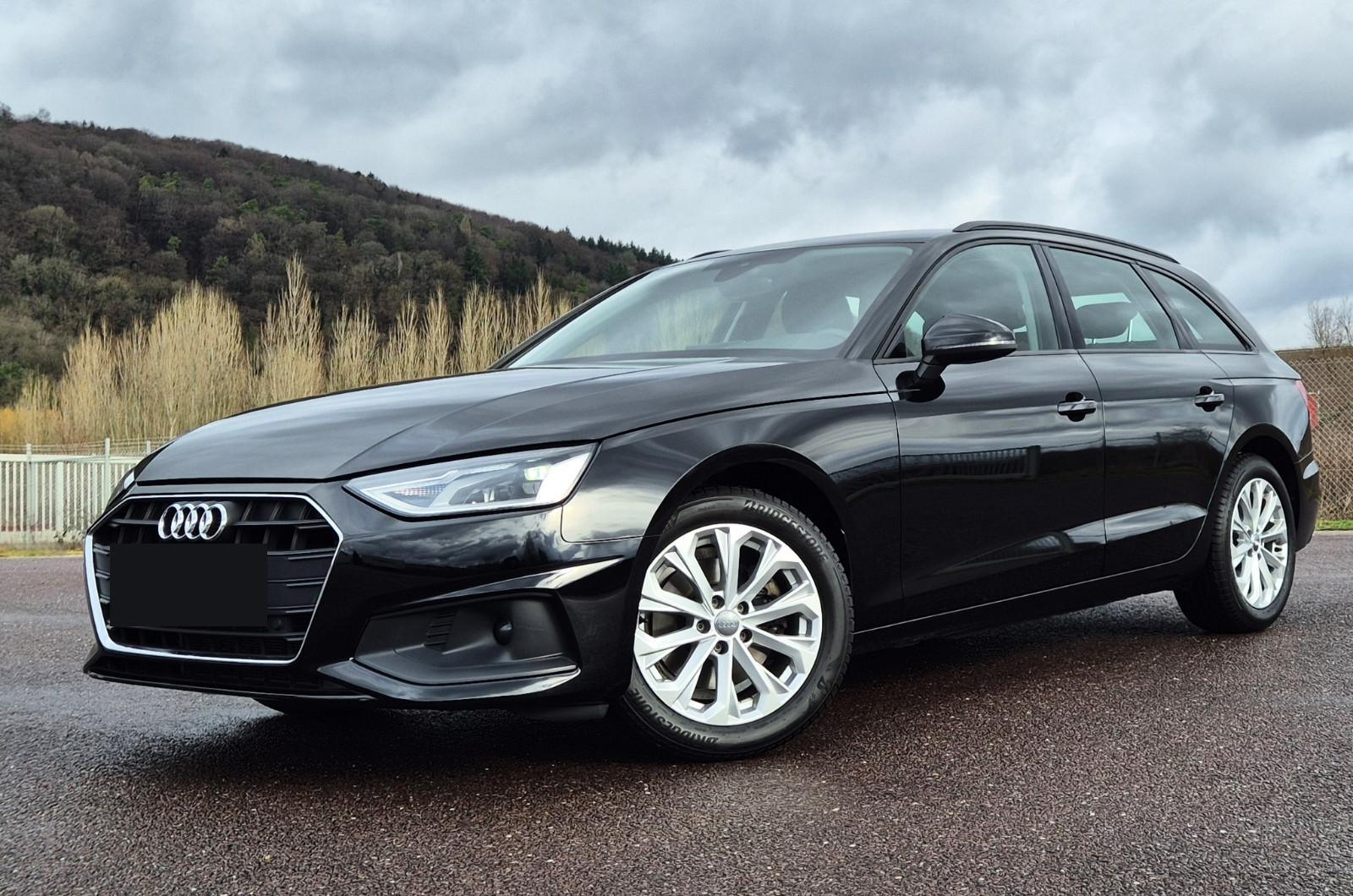 Schwarzer Audi A4 Avant, schräg von vorn links, auf einem gepflasterten Platz vor einem bewaldeten Hang, Gebrauchtwagen bei Frank-Automobile
